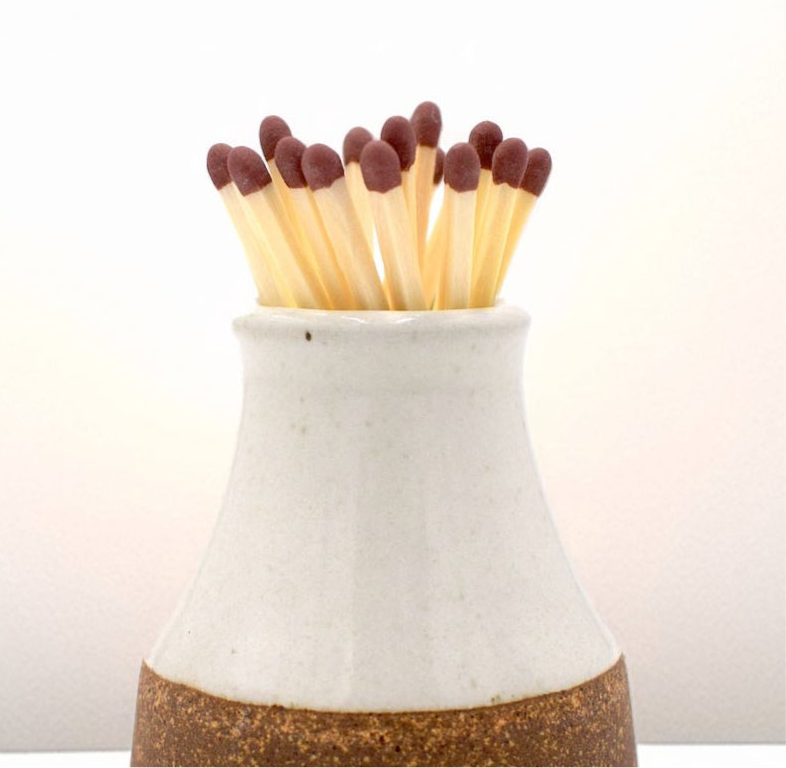 "Close-up of a ceramic match pot, featuring a sleek glazed finish, ideal for storing matches in style. Gift wrapping available to make it the perfect present. this is the white pot