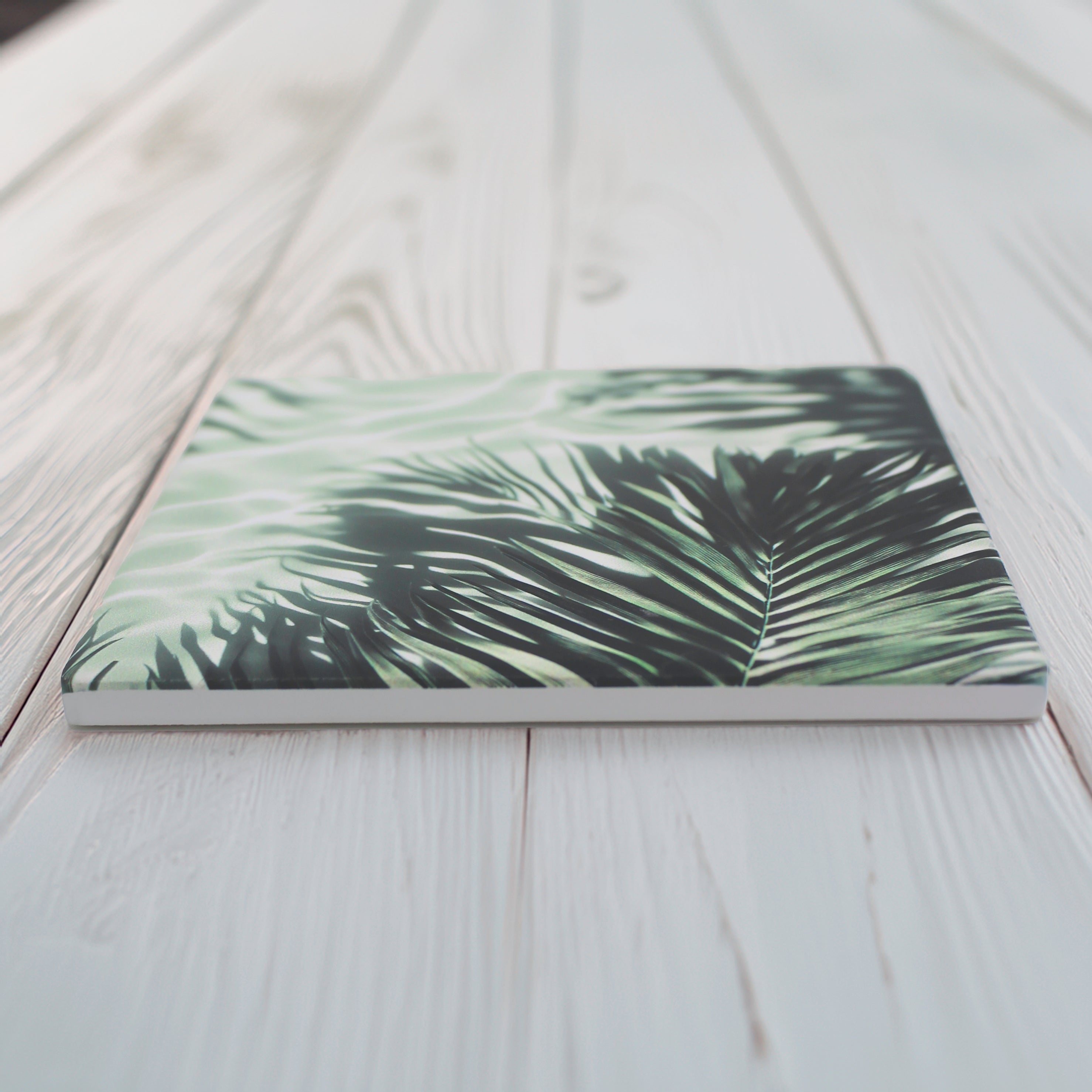 Bring a touch of the tropics to your space with our Jungle Leaf Pattern Ceramic Coaster Set. 
This set of four includes two variations of lush, leafy designs, offering a beautiful mix of botanical style, choose from green or pale grey option.
Available in matte or gloss finish to complement your style. 
Each coaster is finished with a crisp white, cork-backed base for both beauty and practicality.
10 x 10cm