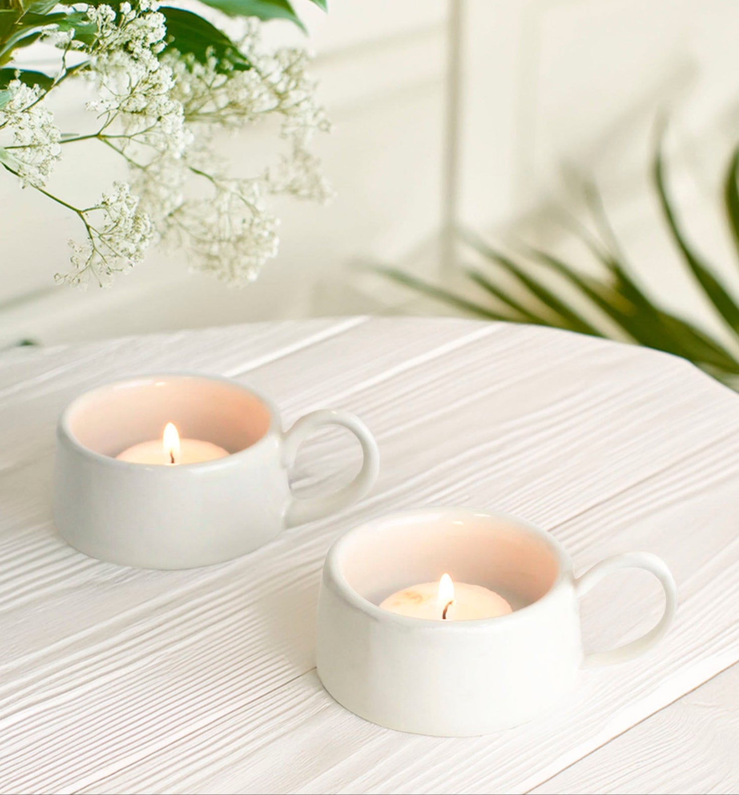 White Variant: "Elegant white ceramic tea light holder with a charming handle and a smooth, glossy finish, perfect for creating a serene ambiance."
