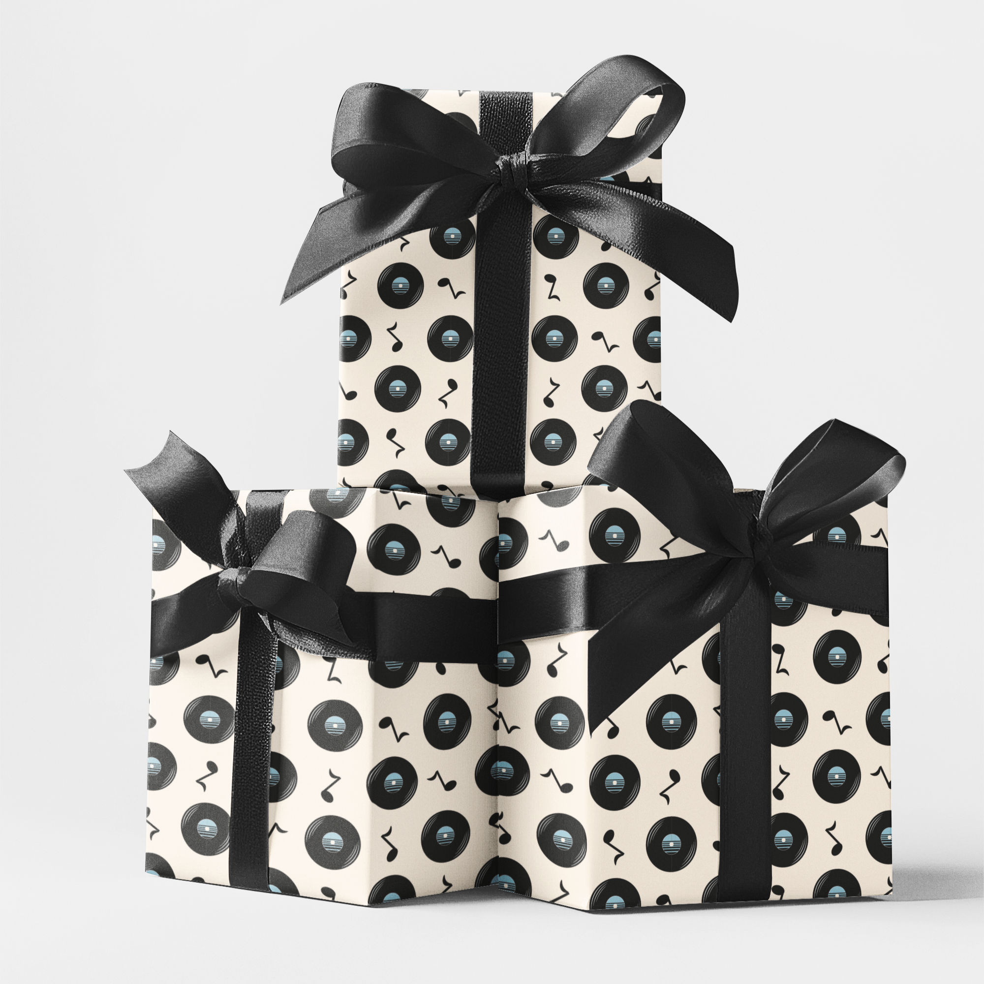 Three gift boxes wrapped in vintage record design perfect for music lovers with black and cream patterned
