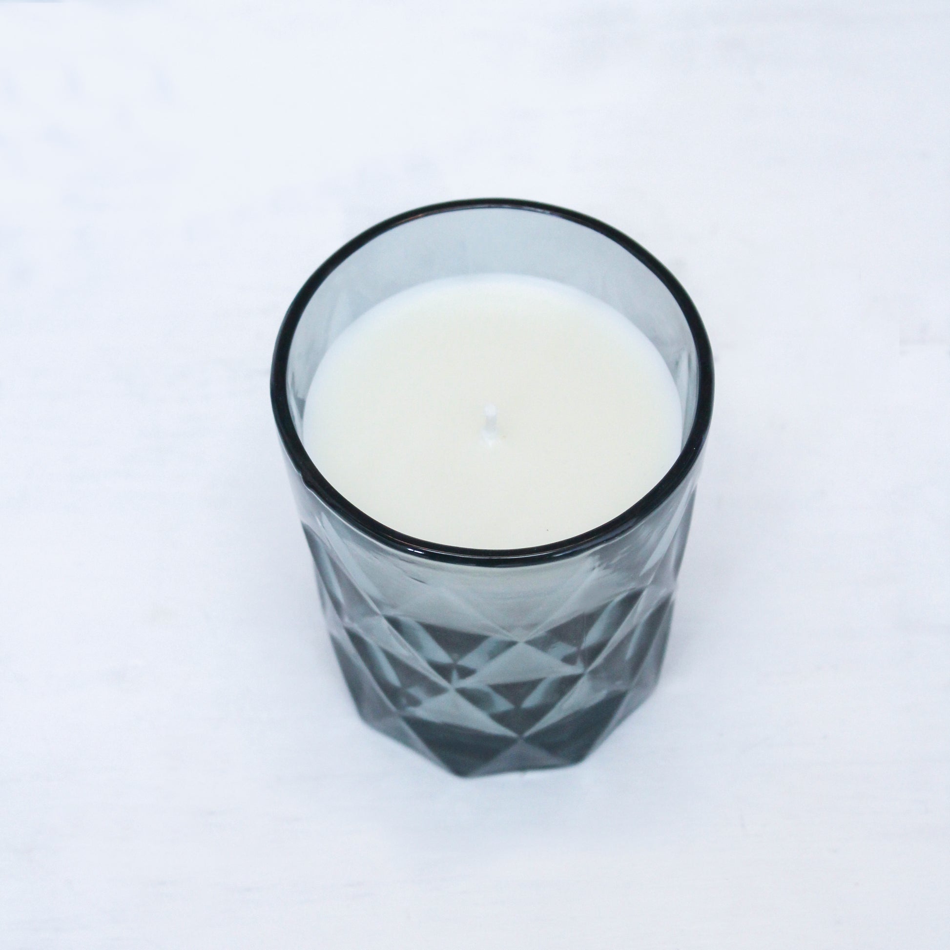 "Fragrance-free blue glass candle holder, perfect for any home décor style, creating a warm, welcoming atmosphere."