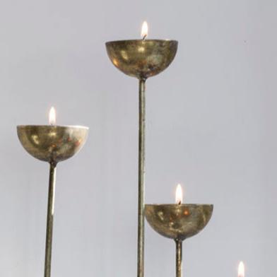 Tea Light Holder Cup: "Delicate tea light holder cups in a soft, muted gold finish, designed to hold tea lights and create a warm, inviting glow."