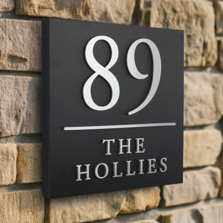 Weather-resistant matte black square house sign featuring silver raised text and a clear dividing line for easy readability.