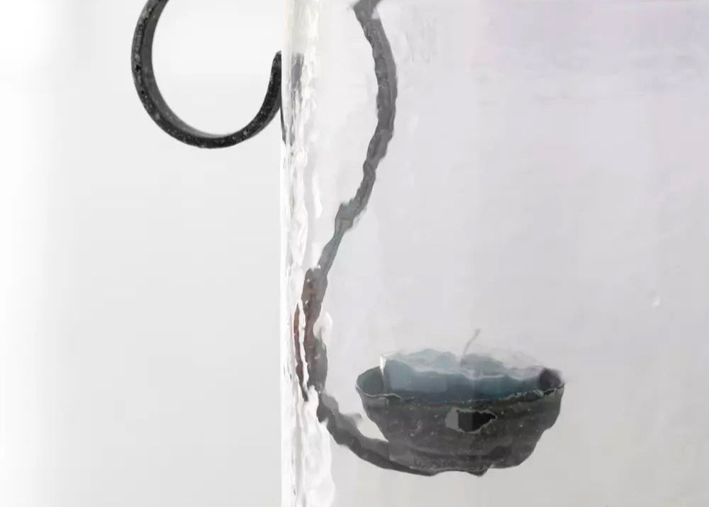 "Close-up of a hanging tea light holder made from durable metal, showcasing its intricate craftsmanship and rustic appeal."
