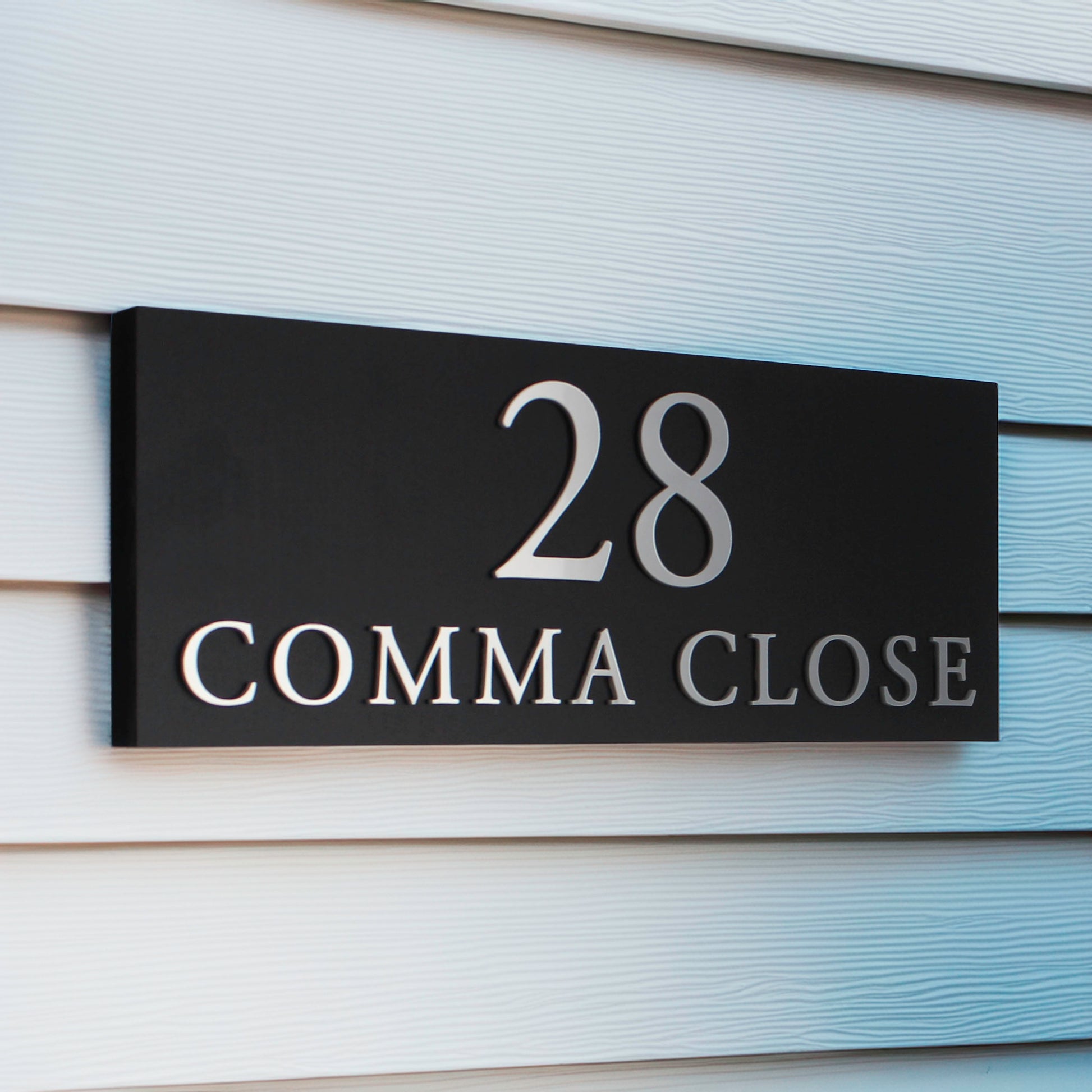 matte black house sign shown with silver raised lettering with number and address