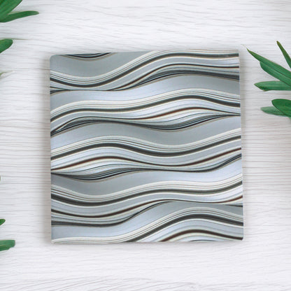 Bring effortless style to any space with our Grey Waves Pattern Ceramic Coaster Set, featuring a beautifully curated mix of intricate wave-inspired designs in classic grey tones, this set of five adds a touch of elegance to any table.

Available to purchase in either a matte or gloss finish, allowing you to choose the perfect look for your space.

 Cork-backed base for both beauty and practicality.

A thoughtful gift for birthdays, housewarmings, dinner parties, or teachers, these coasters bring charm to an