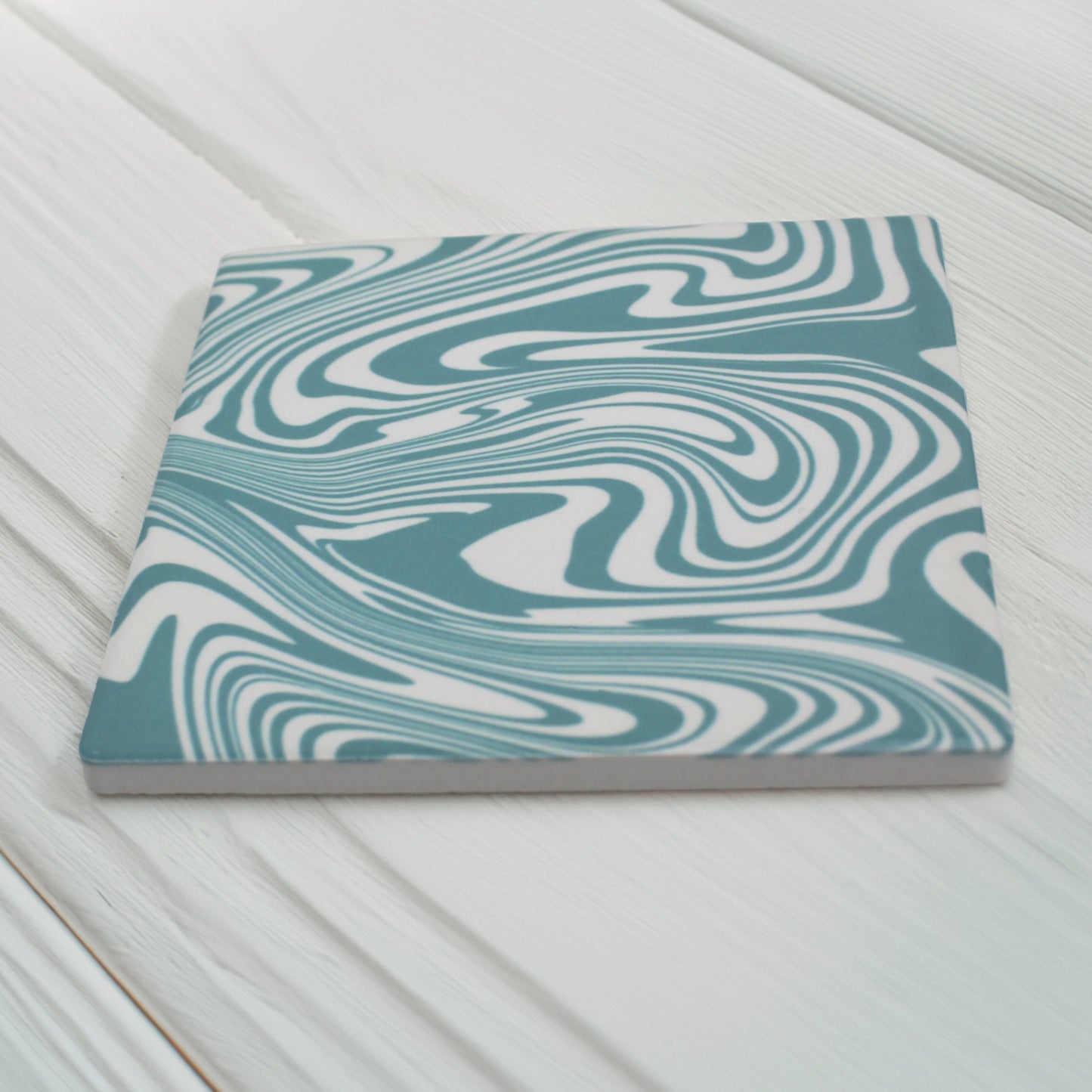 This turquoise and white swirl modern coaster is simply stunning.

Add a burst of personality to your space with our Funky Swirl Abstract Ceramic Coaster Set. Featuring vibrant, playful swirling patterns, these coasters are designed to liven up any room.

Choose from blue, orange, sage green, or yellow. Want a unique combination? You can mix and match up to four colours, just specify your choices and how many of each!

Available in matte or gloss finish to match your style.