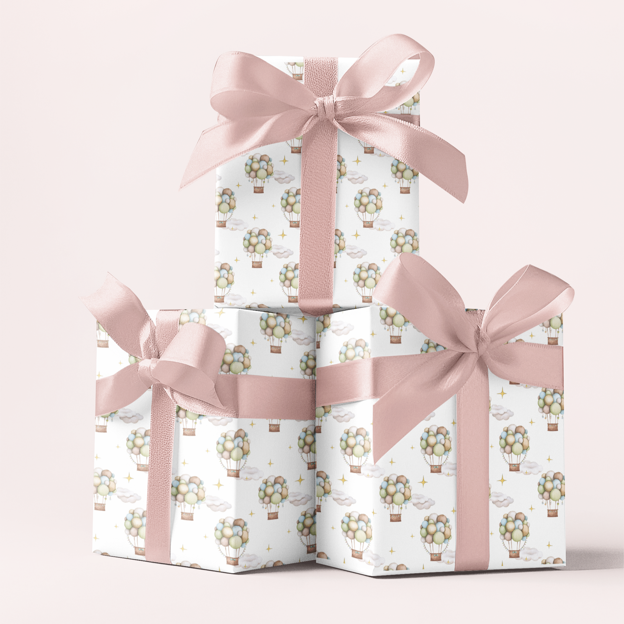 Three gift boxes stacked on top of each other with pink ribbons against a white background