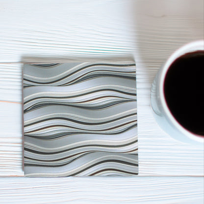 Bring effortless style to any space with our Grey Waves Pattern Ceramic Coaster Set, featuring a beautifully curated mix of intricate wave-inspired designs in classic grey tones, this set of five adds a touch of elegance to any table.

Available to purchase in either a matte or gloss finish, allowing you to choose the perfect look for your space.

 Cork-backed base for both beauty and practicality.

A thoughtful gift for birthdays, housewarmings, dinner parties, or teachers, these coasters bring charm to an