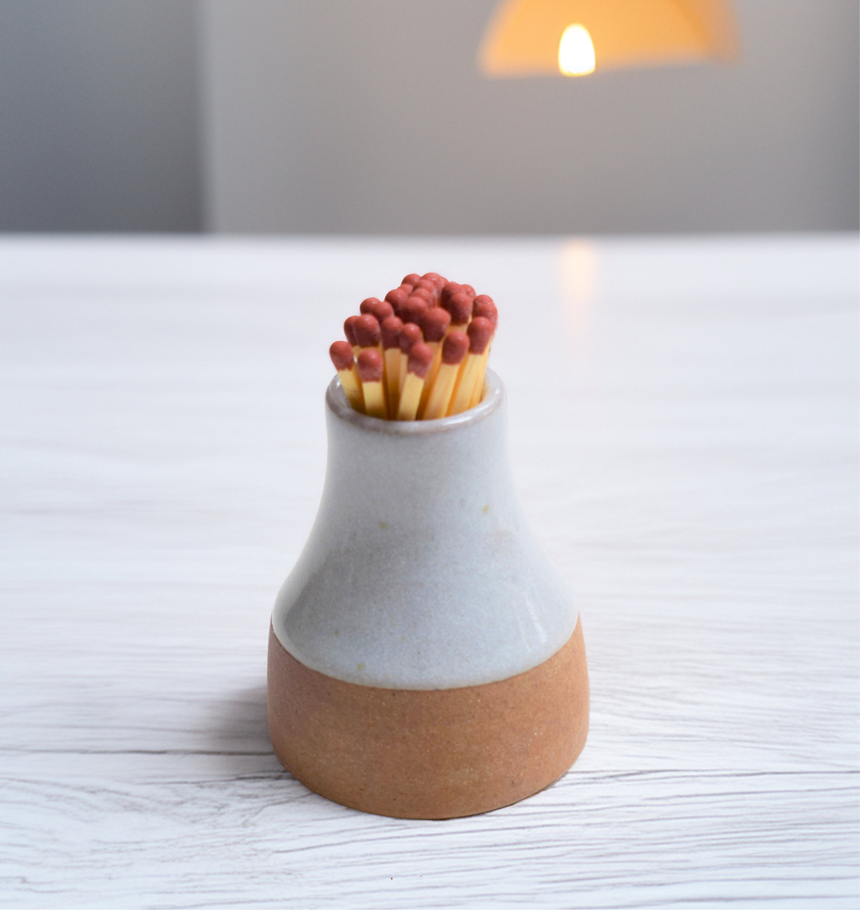 "Charming handcrafted match pot with a glossy ceramic glaze, available in white and grey rustic. Gift wrapping available for easy gifting. this is the pale grey version