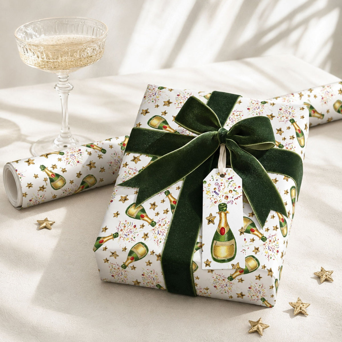 Champagne Celebration gift wrap styled with green velvet ribbon and glass of fizz