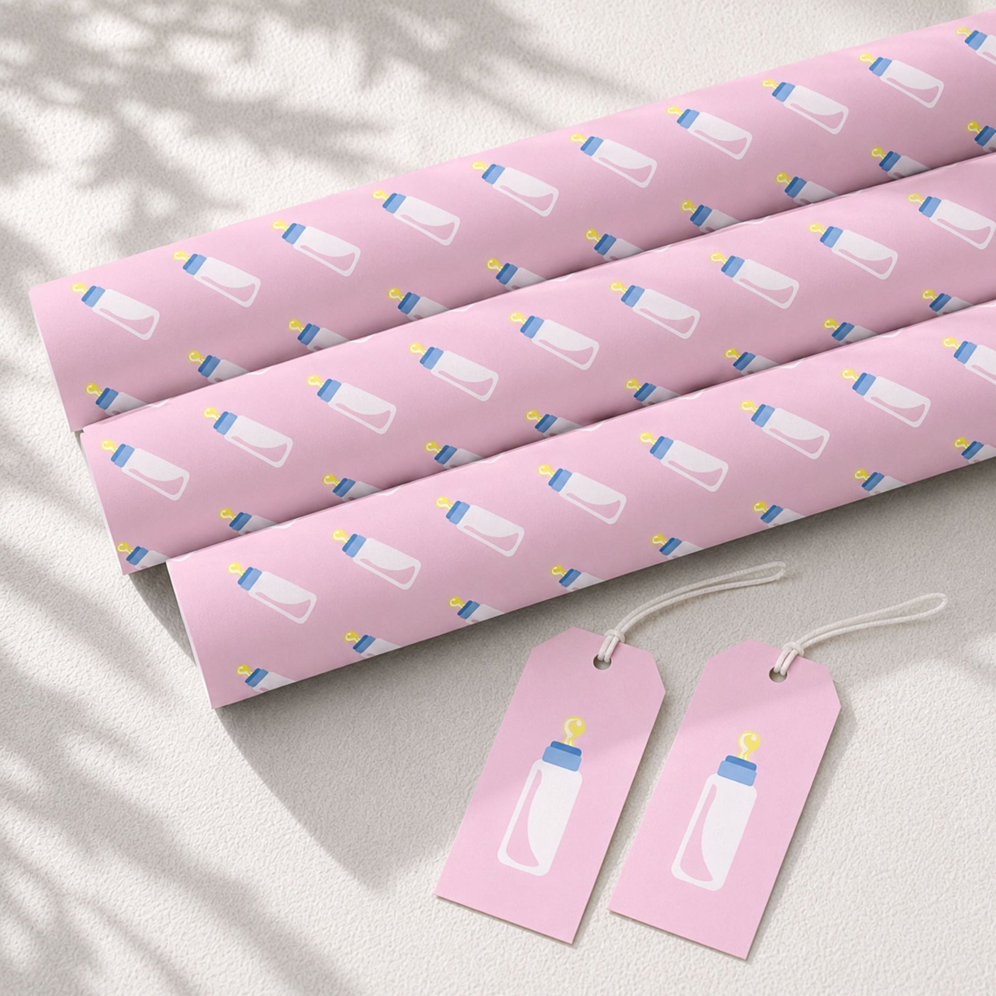 Pink baby bottle wrapping paper rolls with matching gift tags