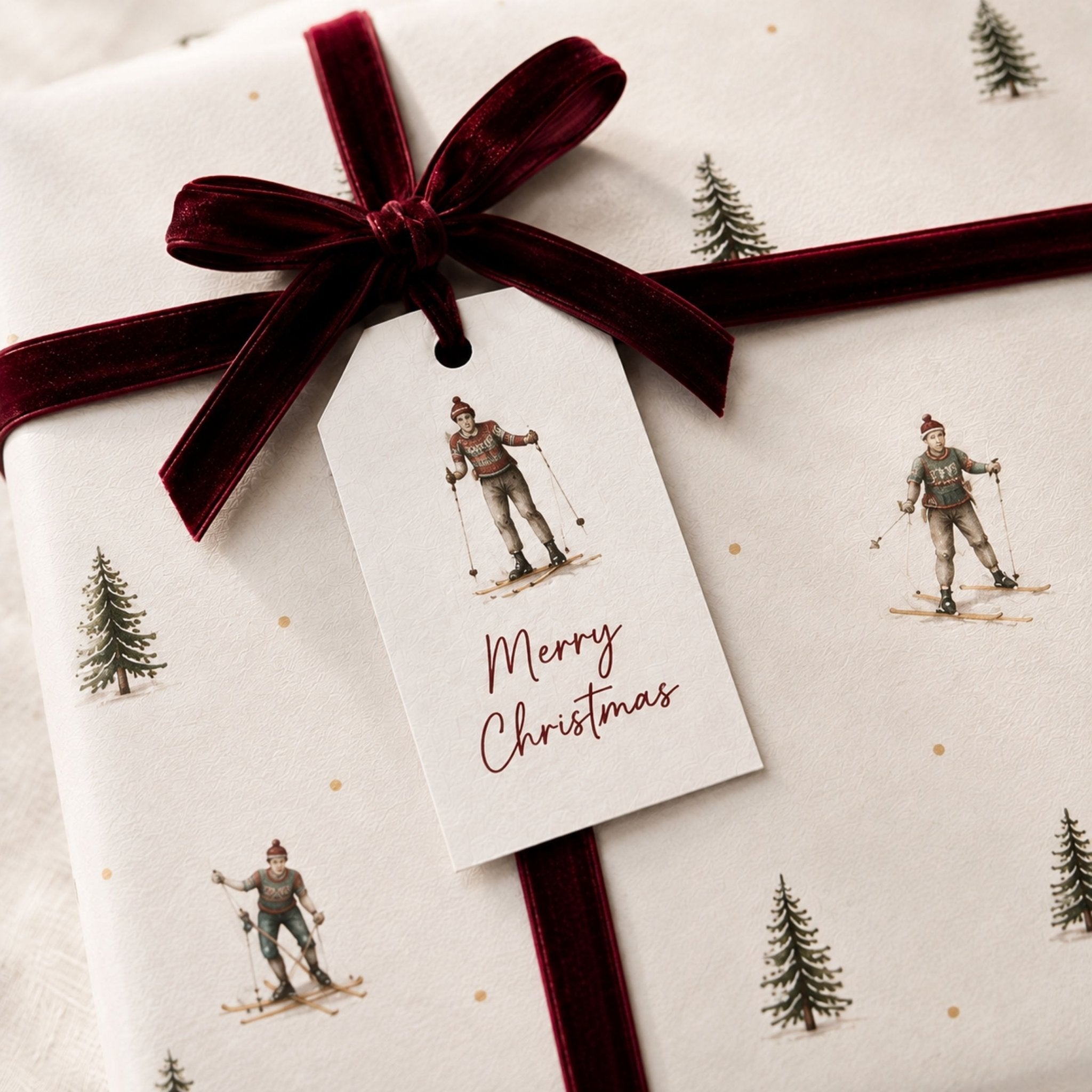 Christmas gift wrapped in delicate tree wrapping paper with burgundy velvet bow and matching gift tag tags included