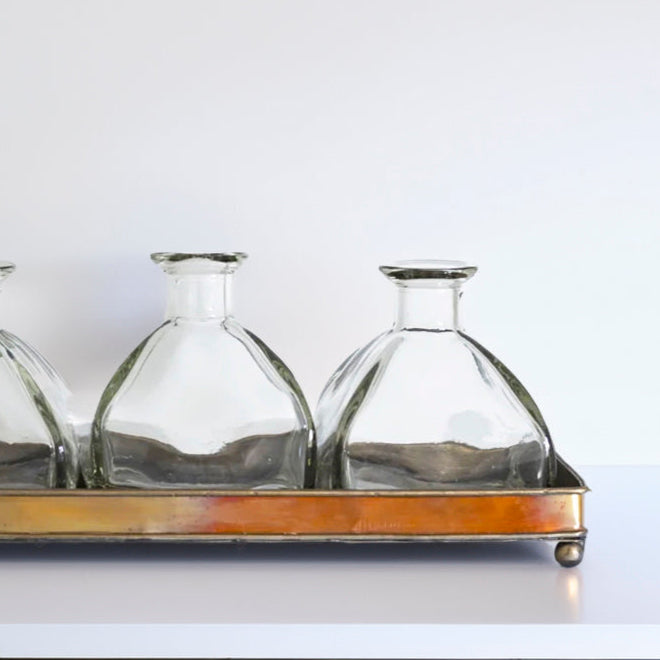Elegant Glass Bottle Vase Set on Copper Tray