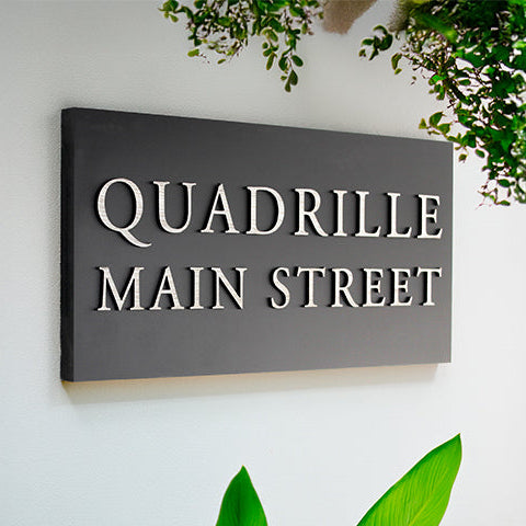 This modern 40 x 20 cm outdoor house sign adds style and durability, making it a perfect way to enhance your home's curb appeal or give as a thoughtful housewarming gift.

Designed with a matte black base, the raised lettering silver, creates a bold three-dimensional look for high visibility.

With space for up to 4 lines of text you can personalise it to suit your style while maintaining a sleek, contemporary design.
