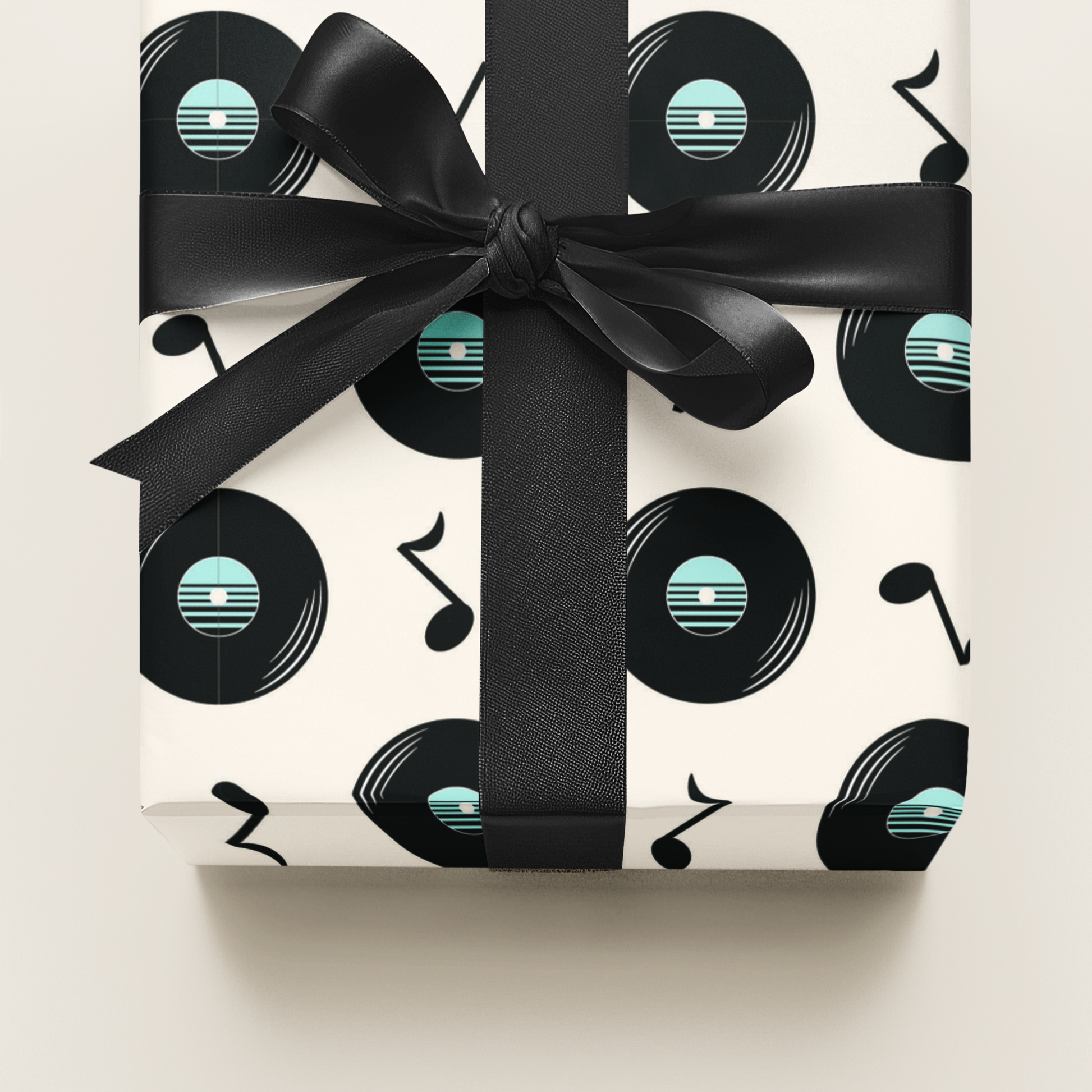 Gift wrapping paper with vinyl record and music note pattern wrapped with a black ribbon on a white background