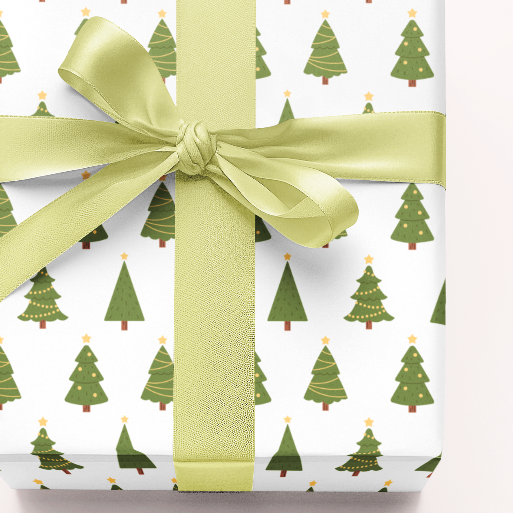 Gift wrapped in paper with green tree pattern and tied with a green ribbon on a white background