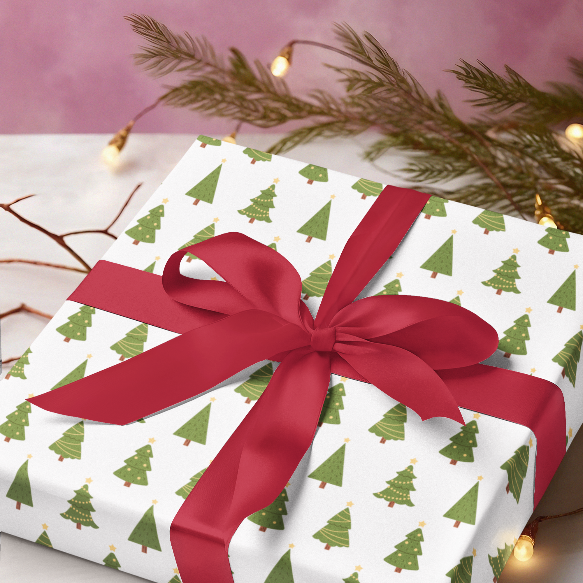 Gift wrapped in Christmas tree pattern paper with a red ribbon on a pink background.