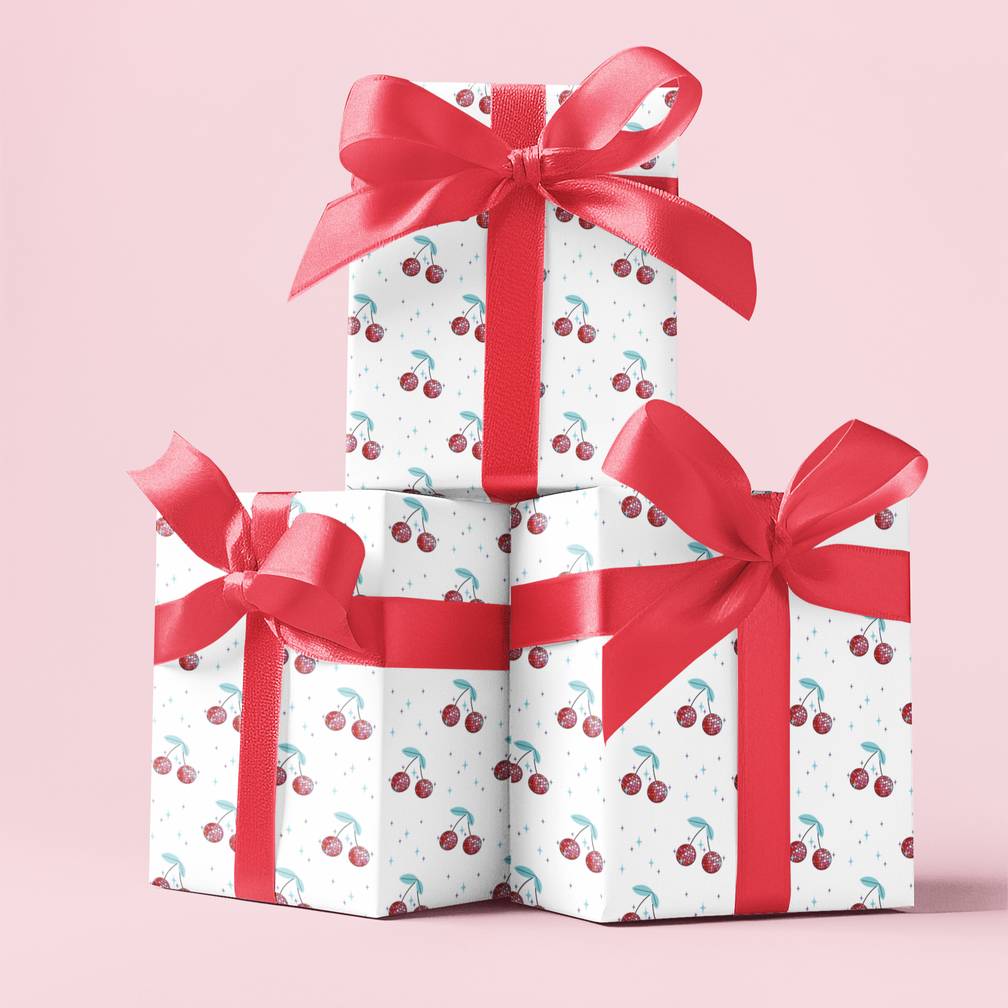 Three gift boxes wrapped with cherry disco balls pattern and red ribbons stacked on a pink background