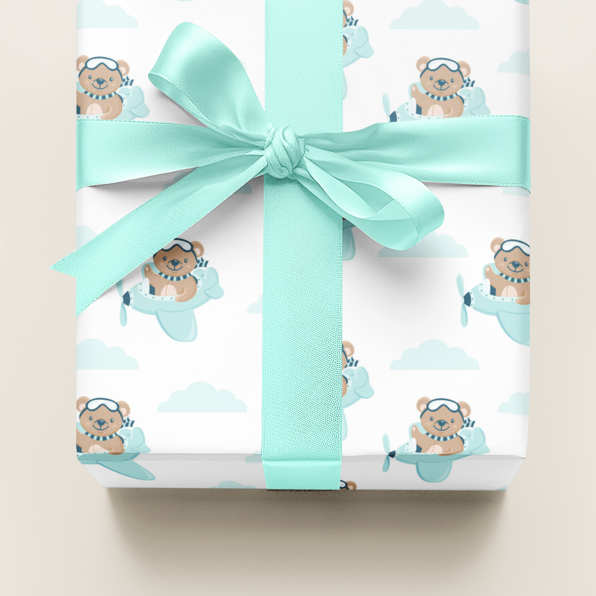 Gift wrapping  paper with teddy bear design and a turquoise ribbon on a light background