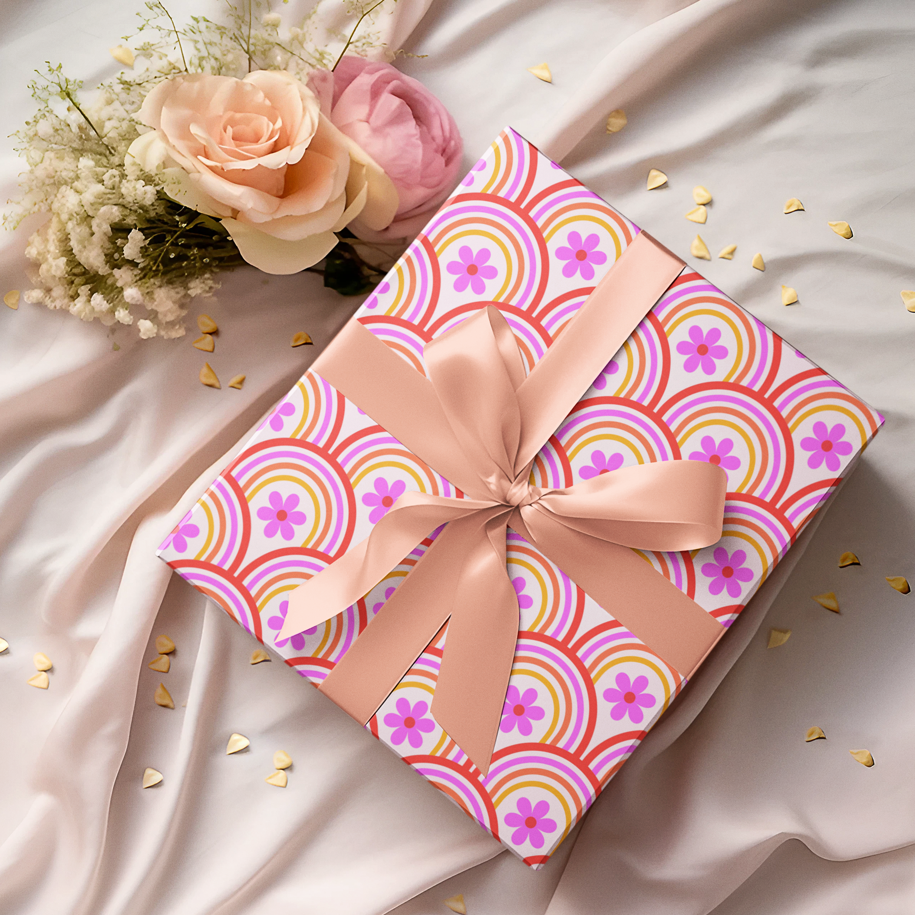 Gift wrap paper with pink and orange pattern and bow on a soft fabric background with flowers. this comes in 2 sizes