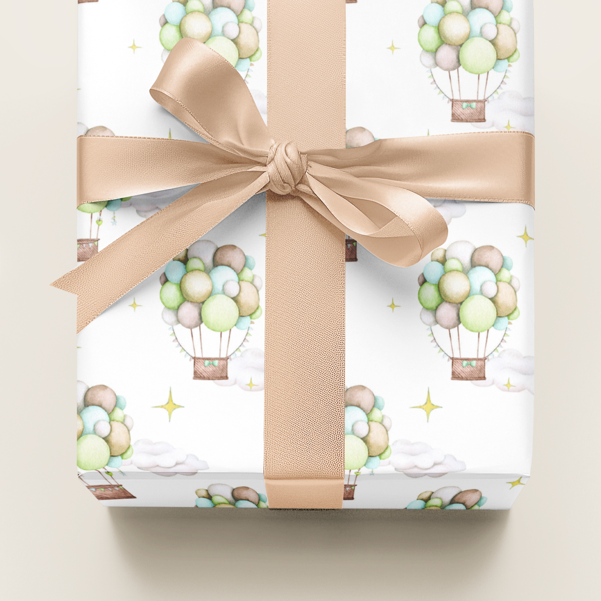 Gift box with hot air balloon pattern and beige ribbon on a light background