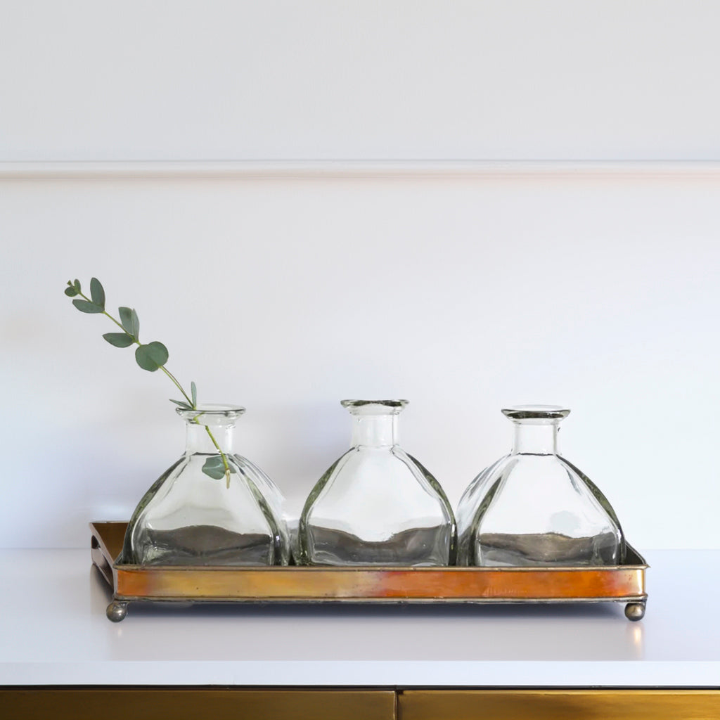 Elegant Glass Bottle Vase Set on Copper Tray