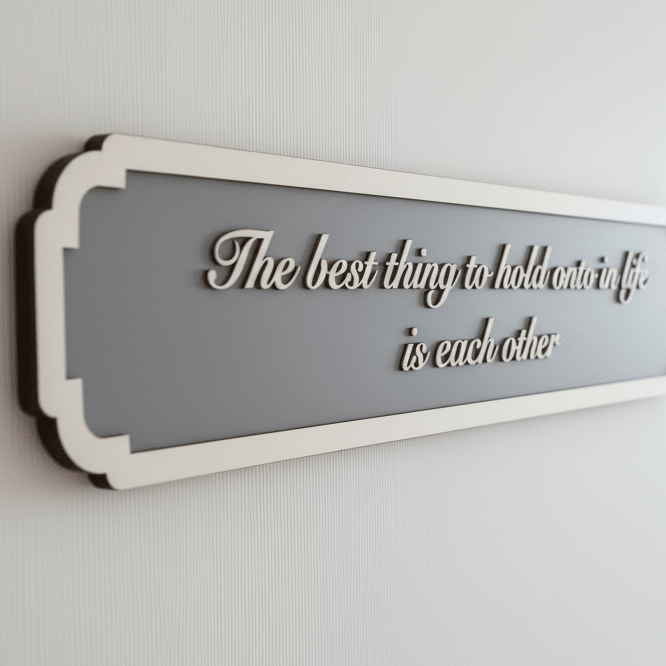 Angled close-up of a grey quote sign showing the depth of the raised wooden script and decorative border.