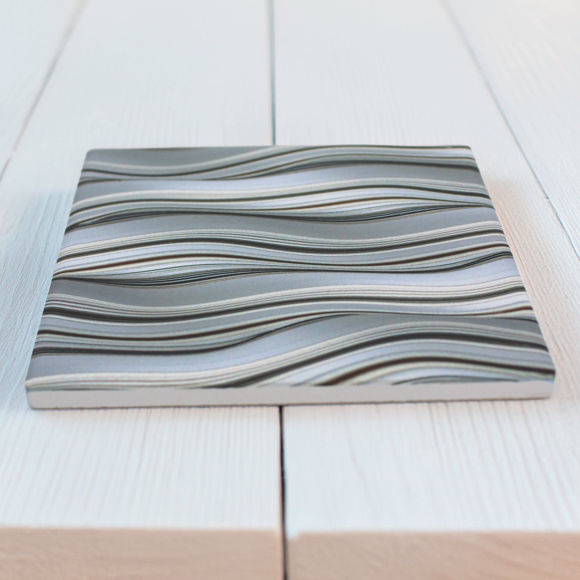 Bring effortless style to any space with our Grey Waves Pattern Ceramic Coaster Set, featuring a beautifully curated mix of intricate wave-inspired designs in classic grey tones, this set of five adds a touch of elegance to any table.

Available to purchase in either a matte or gloss finish, allowing you to choose the perfect look for your space.

 Cork-backed base for both beauty and practicality.

A thoughtful gift for birthdays, housewarmings, dinner parties, or teachers, these coasters bring charm to an