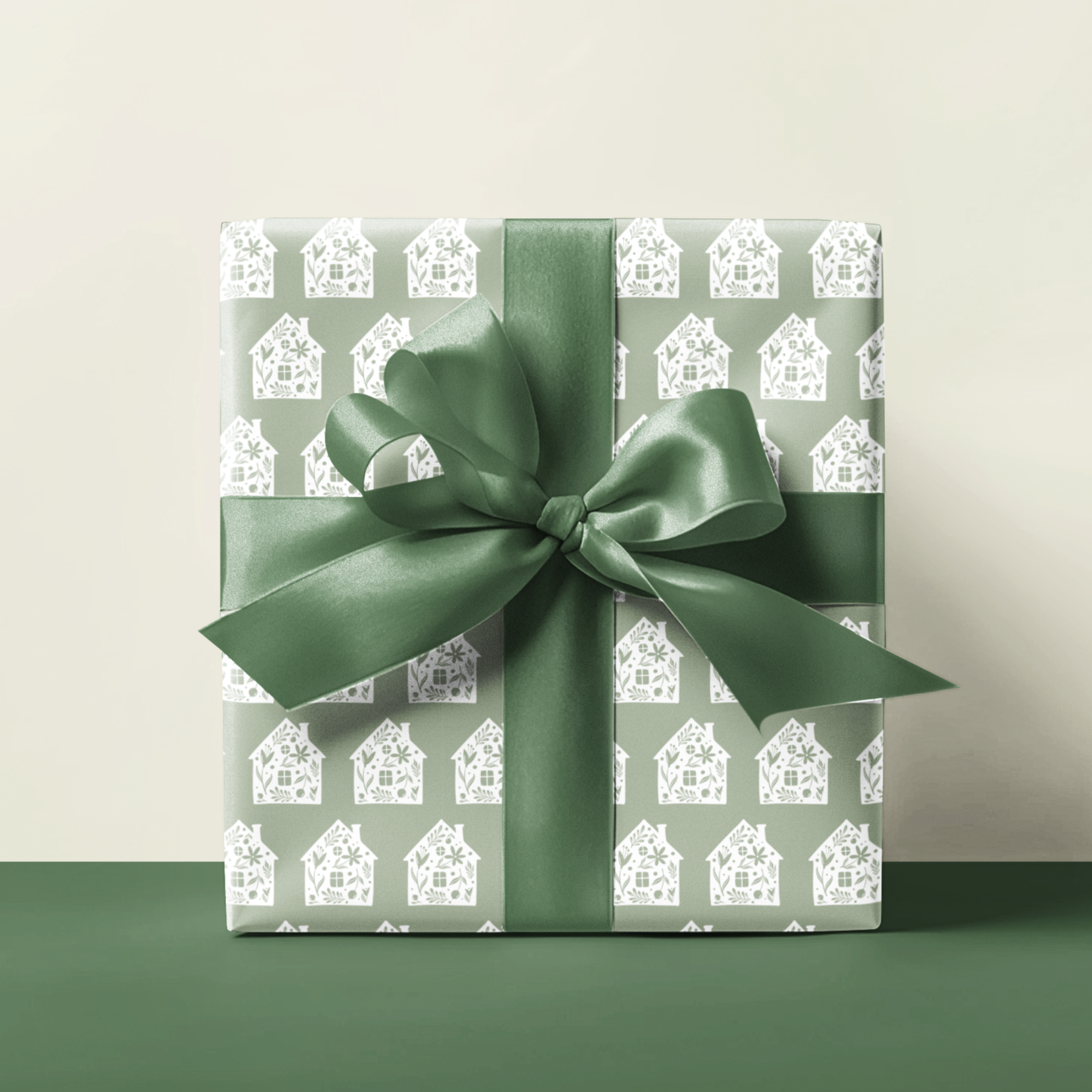 Gift box with green backing and house design ribbon on a light background