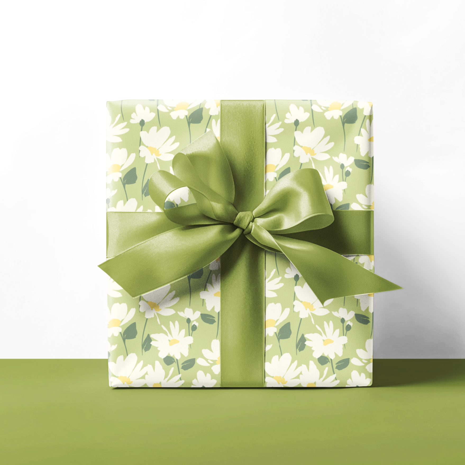 Gift box with green floral pattern and bow on a white background