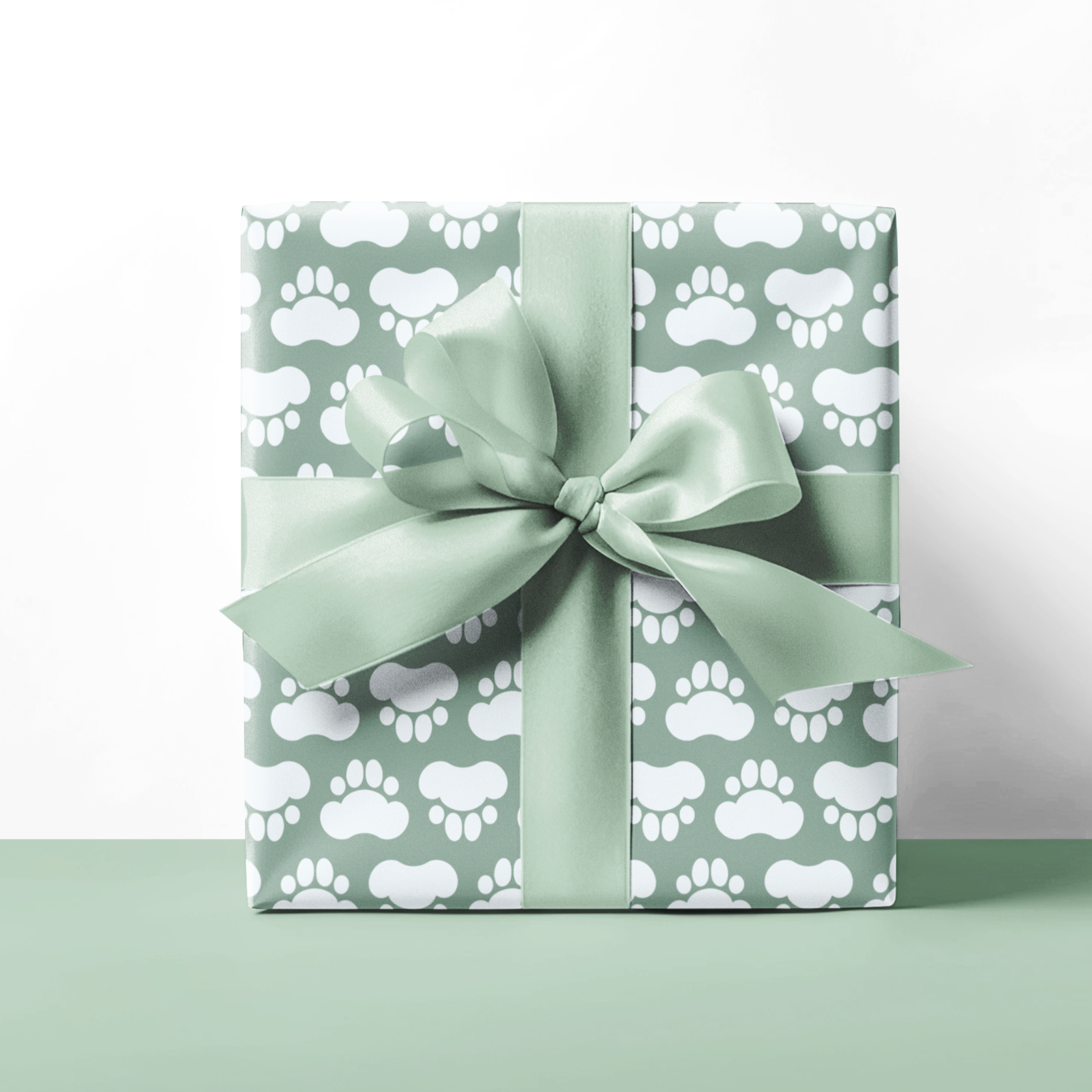 Gift box with paw print pattern and green ribbon on a white background