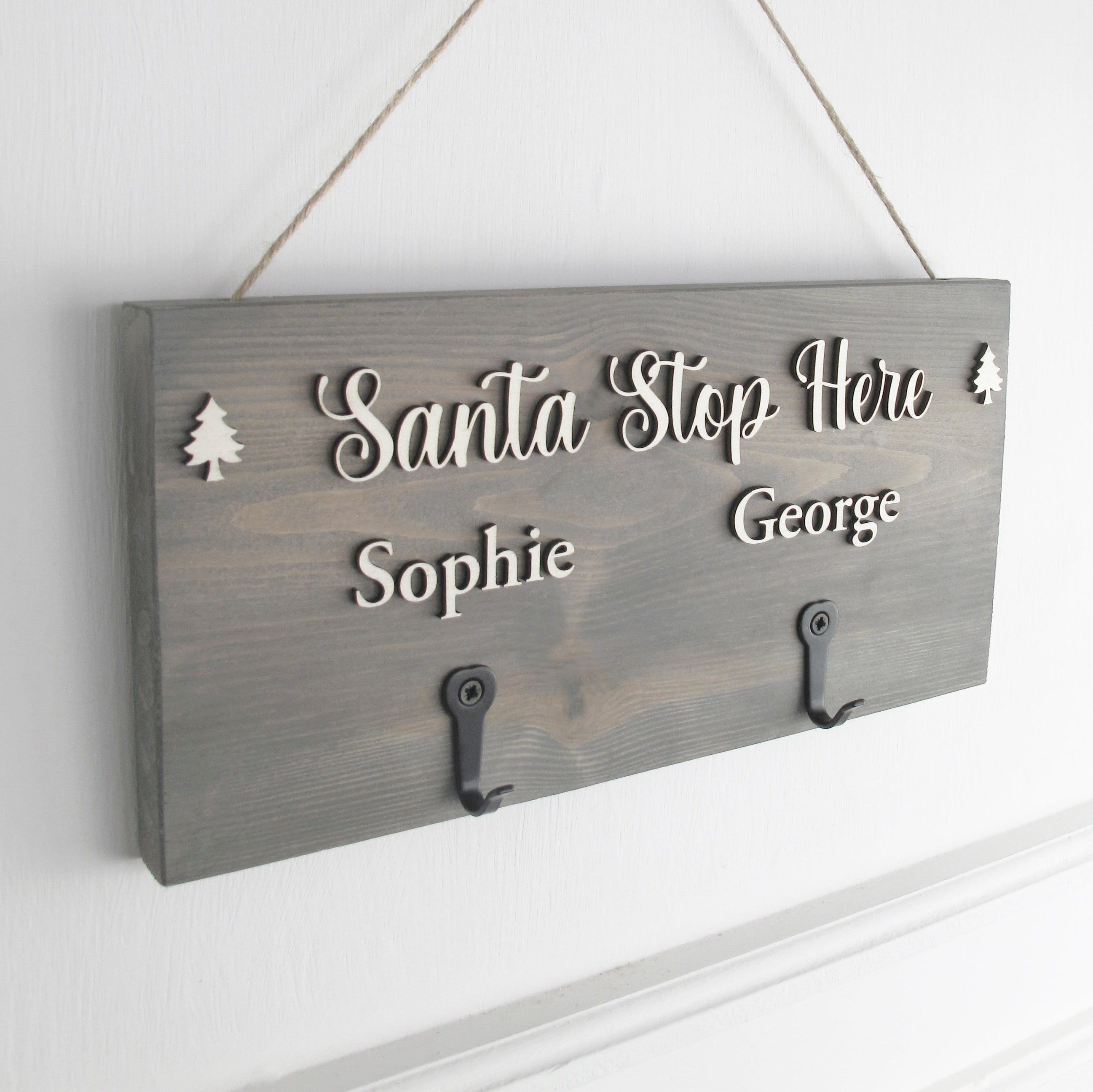 Wooden sign with 'Santa Stop Here' and names on a white wall