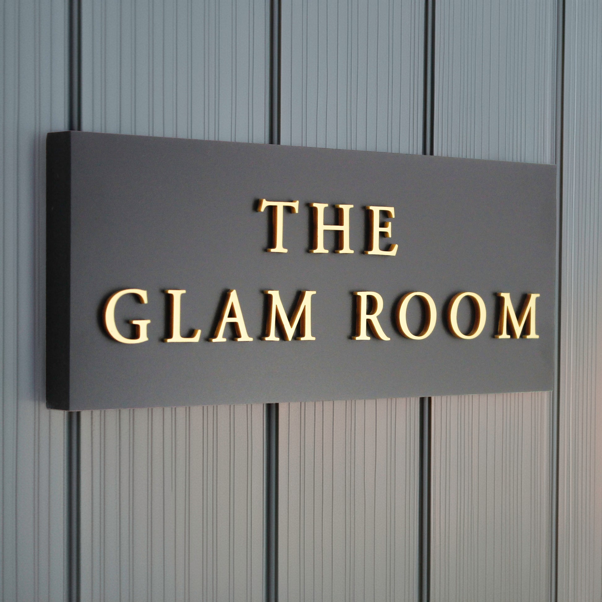 Black sign with gold text 'perfect for a beauty salon door