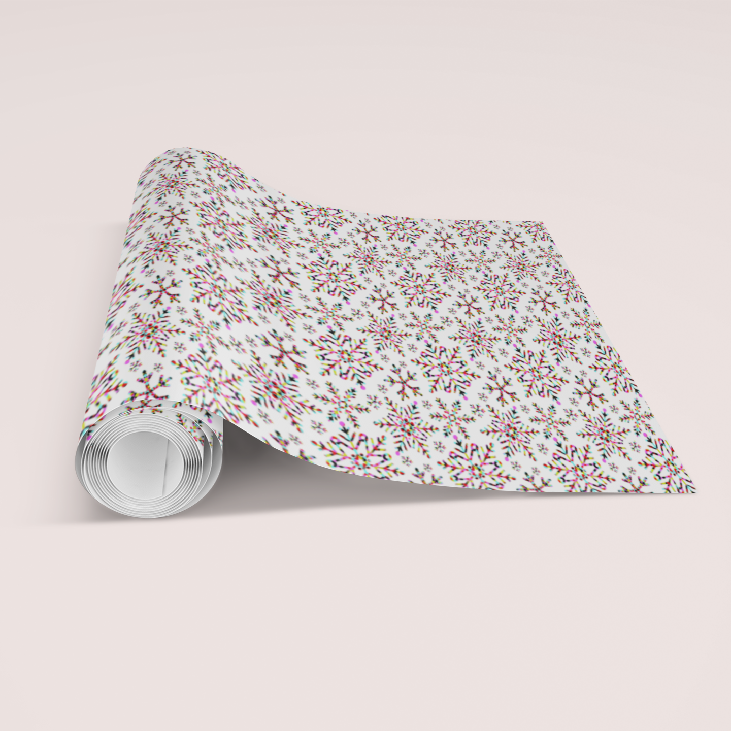 Roll of  multi coloured snowflake Christmas patterned paper on a light pink background