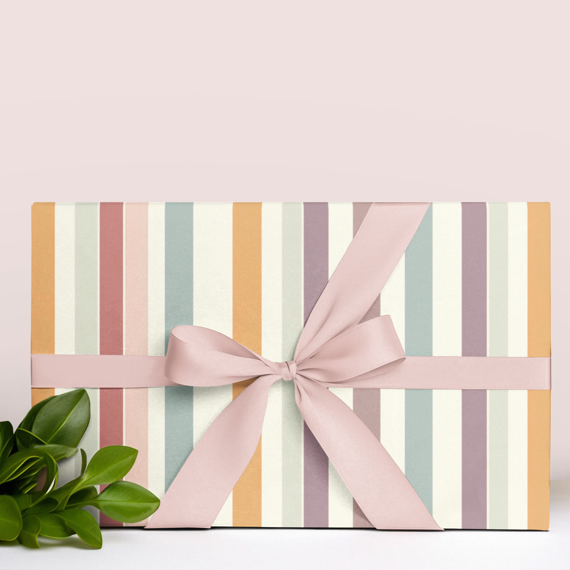 Gift wrap paper with striped pattern and pink ribbon on a light background