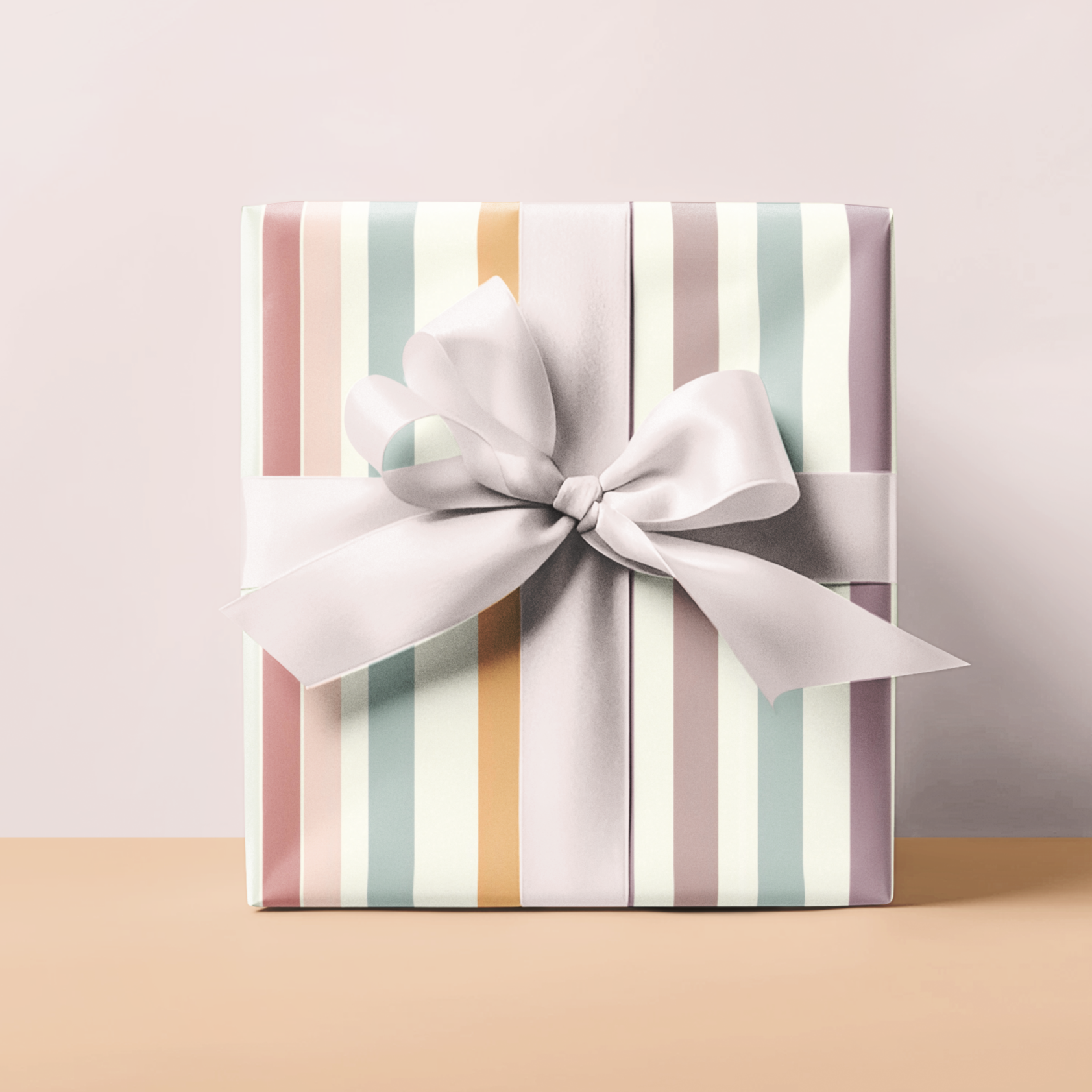 Gift box with striped pattern and white bow on a beige surface and light pink background