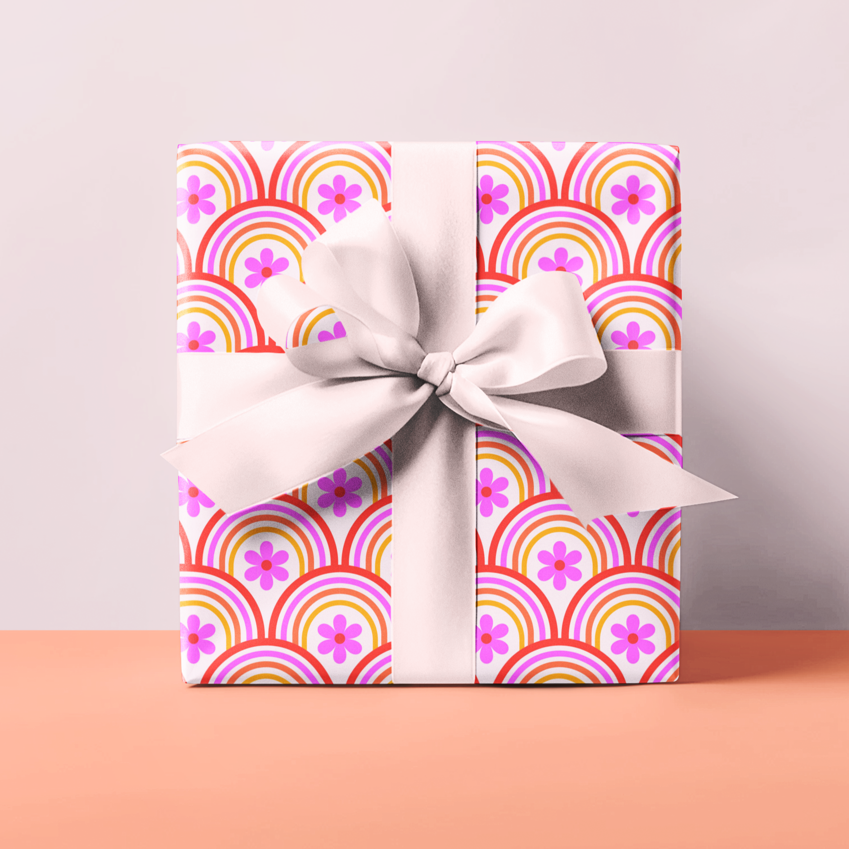 Gift wrapping paper with funky retro pattern and white bow on a pink surface